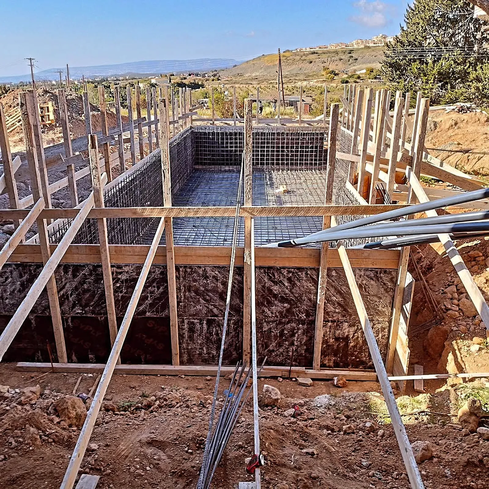 Excavated pit with steel reinforcement cage and timber formwork