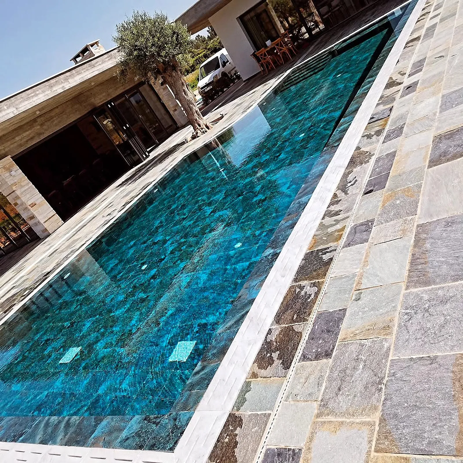 Finished pool with green mosaic tiles and slate stone surround