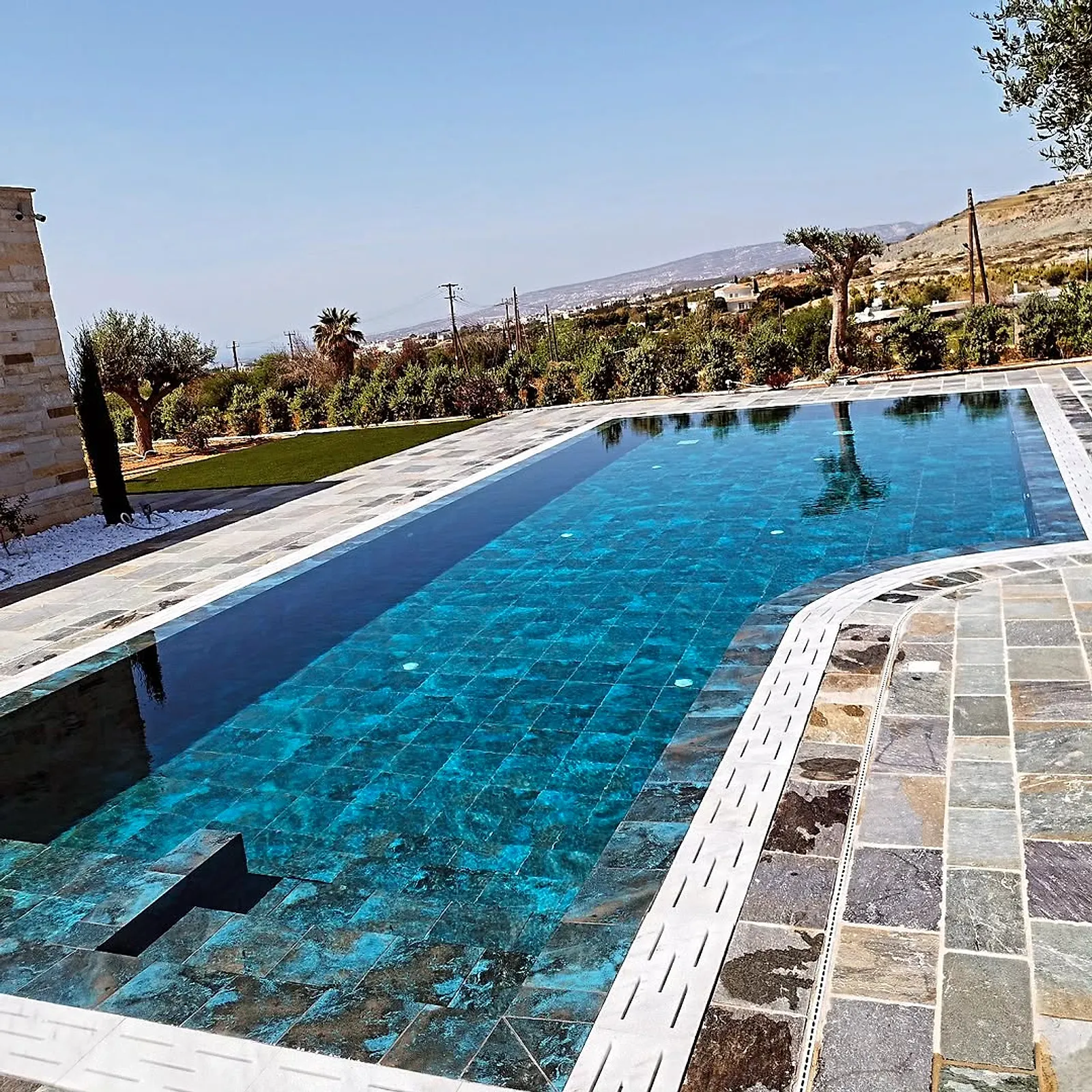 The finished pool full of water with a view over the hills